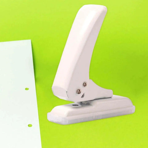 Portable Workhorse One Hole Punch Handheld Metal Hole Puncher With 40 Sheet Paper Capacity on green background with punched paper