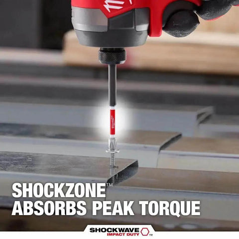 Close-up of Shockwave Bit And Drill Bit Kit With 60 Pieces For Impact Drivers And Drills Delivering Long Lasting Performance And Up To 50 Times Longer Life For Hardcore Jobs By Milwaukee 48 32 4097, showing a screwdriver bit engaging a metal screw with 'Shockzone Absorbs Peak Torque' text.