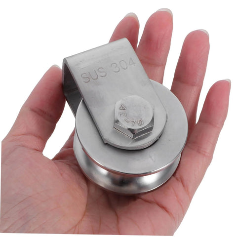 Hand holding a Stainless Steel Industrial Pulley Wheel For Cable Guide Roller Heavy Duty Beefy Roller Ideal For Door Track And Rolling Gate Systems