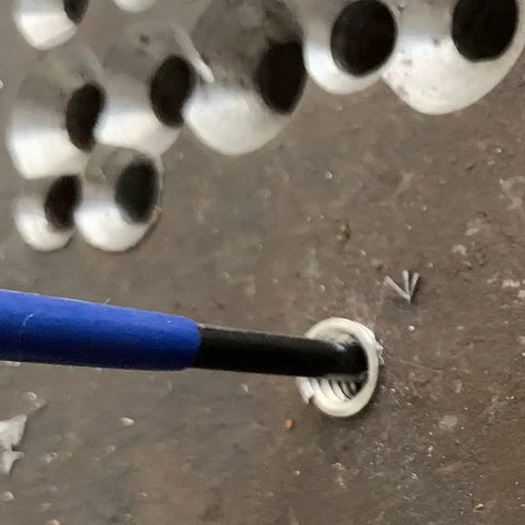 Close-up of M5 X 0.8 Helical STI Thread Repair Kit being installed with driver and tang in a metal surface for thread fix.