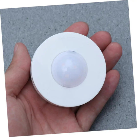 Hand holding a single light from Six Pack LED Cabinet Lights Set With Dimmable Warm White Under Cabinet Lighting For Cupboards Kitchen And Office Use Touch Control Dimmer And Easy Install For Adjustable Brightness