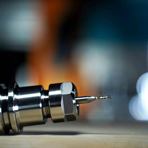 Close-up of a carbide CNC bit showing a down cut spiral router bit with a quarter inch shank. Part of a Down Cut Spiral Router Bit Set For Wood Milling Pro Grade, Five Pack, Quarter Inch Shank, One Eighth Inch Cutting Diameter, Carbide CNC Bits For Precise Grooves, Dados, Mortises, And Slots.