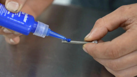 Applying medium strength blue thread locker to bolt for automotive, prevents loosening, seals and protects threads from corrosion.