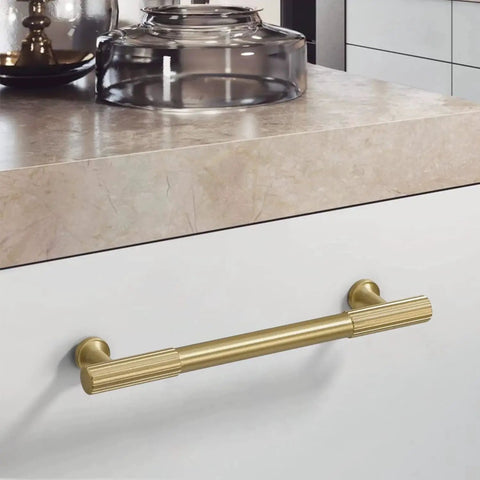 Brushed Gold Modern Kitchen Cabinet Handles Set 5 Pack Solid Brass Drawer Pulls installed on a white kitchen cabinet drawer.