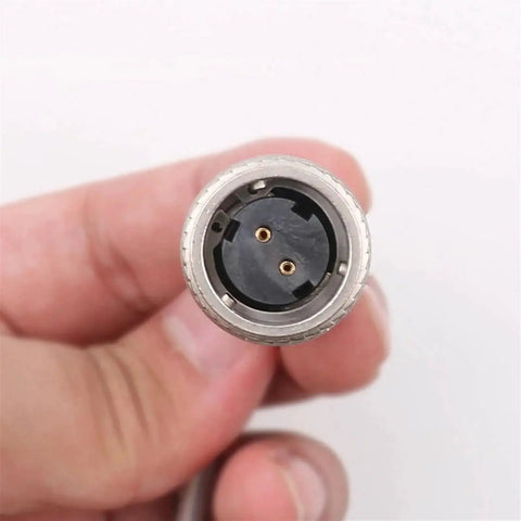Front view of circular metal 2-pin connector end with black plastic insert and two gold contacts