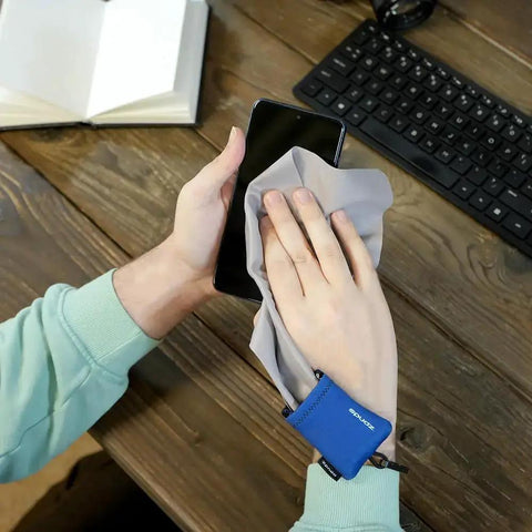 Person cleaning smartphone with Premium Microfiber Screen Cleaner Cloth in Neoprene Pouch with Clip for Glasses.