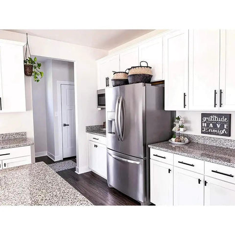 Modern kitchen with 25 Pack 3 Inch Black Cabinet Pulls Stainless Steel Drawer Handles visible on white cupboards around a fridge.