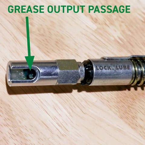 Low Profile 90 Degree Push On Slotted Grease Coupler for hard-to-reach fittings on wooden surface, focus on grease output passage.