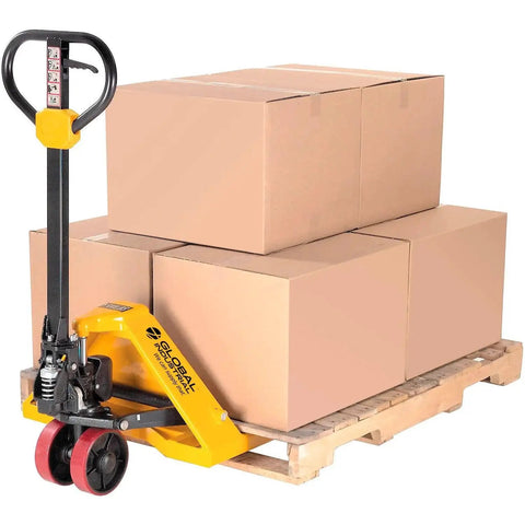 Global Industrial manual pallet jack in yellow with red wheels lifting stacked cardboard boxes on a wooden pallet.