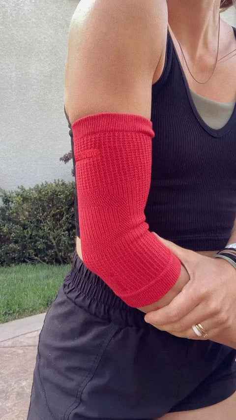 Woman wearing red Elbow Sleeve For Joint Pain Relief And Inflammation Reduction With Circulation Boost All Day Comfort outdoors