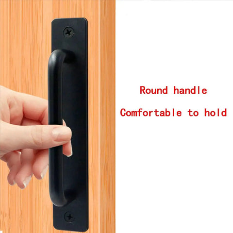 Close-up of Metal Barn Door Pull Set, Four Pack Long Base Flat Head Drawer Pulls, black finish, being held on wood door.