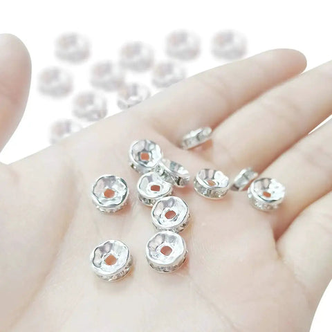 Hand holding 200 Pcs Crystal Rondelle Spacer Beads 8mm Silver Plated for jewelry making and beadwork, showing shiny bright silver finish
