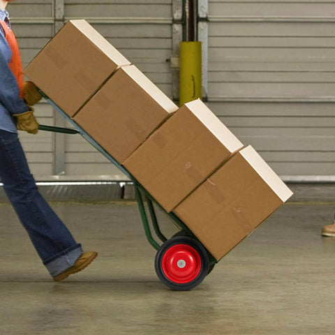 Four Pack 8 Inch Solid Rubber Wheels For Hand Trucks Flat Free Quiet Durable Replacement Wheels With One Half Inch Axle Hole 220 Pound Load Capacity Rust Resistant No Flats Built For Tough Jobs in use on a hand truck carrying boxes.