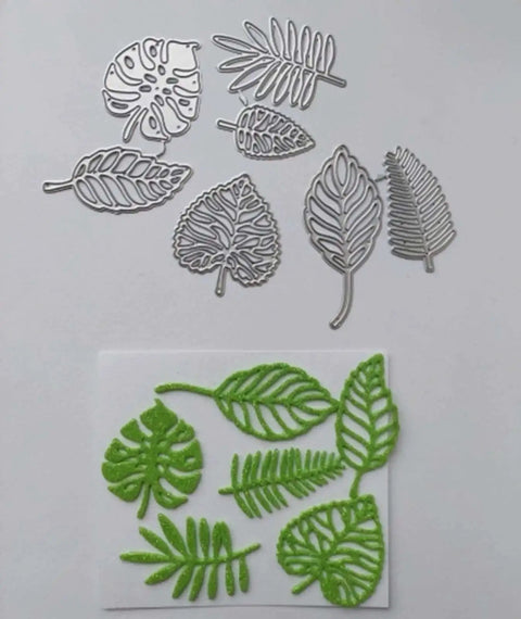 Totally Seven Piece Leaf Die Cut Set For Scrapbooking And Card Making with silver carbon steel leaf shapes and green stencil cutouts.