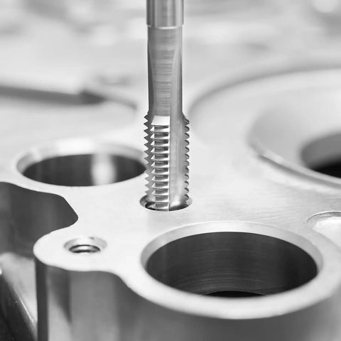 Close-up of threading tool cutting into metal, part of Pro Grade 110-Piece Tap and Die Set with Metric Sizes M2 to M18, Bearing Steel Taps and Dies.