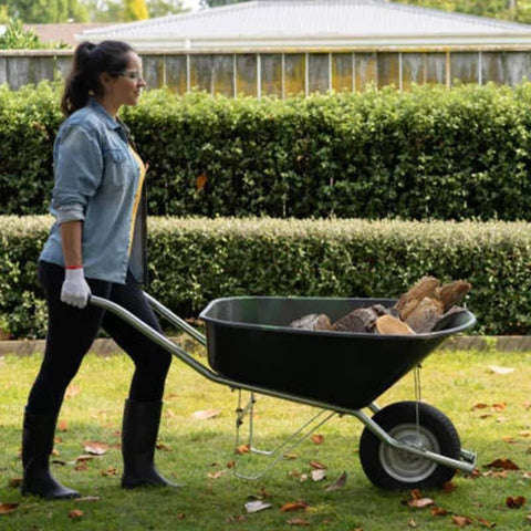 Woman moving a wheelbarrow with 2-Pack Pneumatic Air Filled 10 Inch Hand Truck Wheels With 4.10/3.50-4 Tires in garden
