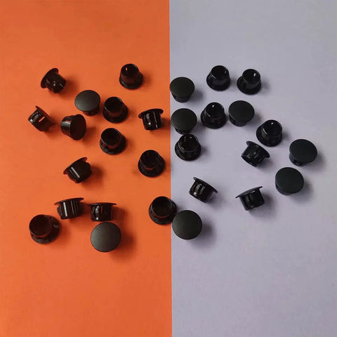 Thirty Pcs Black Plastic Hole Plugs For Cabinet And Screw Holes, 13 Mm Bottom Diameter, Caps On Orange and Gray Background