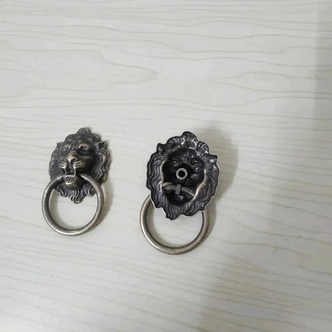 Front view of Antique Bronze Lion Head Ring Pull Cabinet Handles Set Of 4 With Screws, 2.6 Inches Long, on a light background.