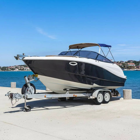 Boat on trailer by water, showcasing Two Pack 5.30-12 Trailer Tires On 12 Inch Rims With Five Lug On 4.5 Inch Bolt Pattern Center Bore 2.95 Inches.