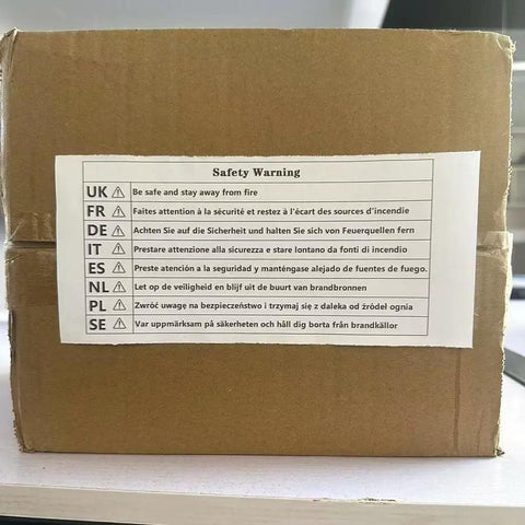 Cardboard box with multilingual safety warning label advising to stay away from fire.
