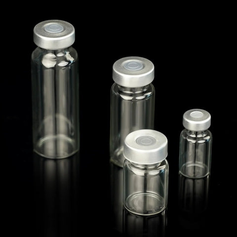 Set of 4 clear glass 2ml sample vials with silver caps on black background