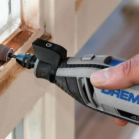 Hand using rotary tool with Beast Half Inch Coarse Sander Bands Set For Rotary Tools 60 Grit 6 Pack Dremel Compatible on window frame