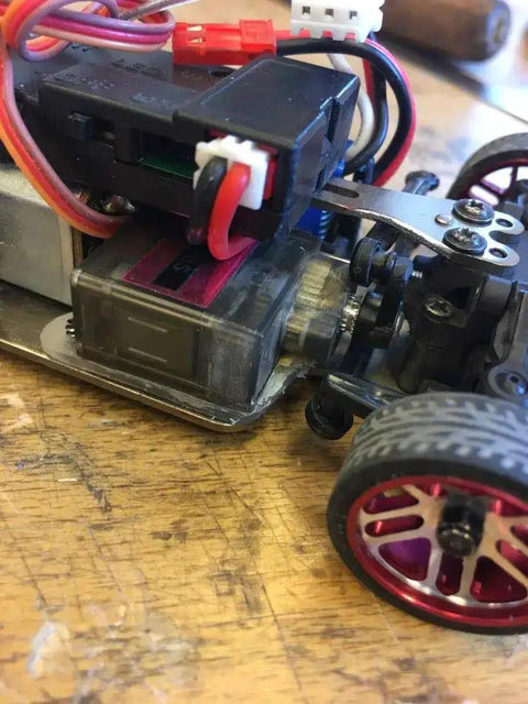 Close-up of 9G micro servo motor installed in RC car, showcasing 360-degree gearing for Raspberry Pi projects