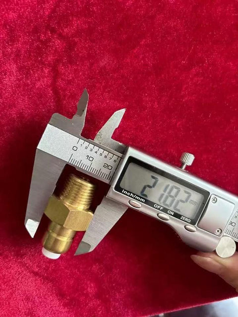 Brass thermal relief valve with 3/8 inch NPT threads measured by digital caliper on red fabric