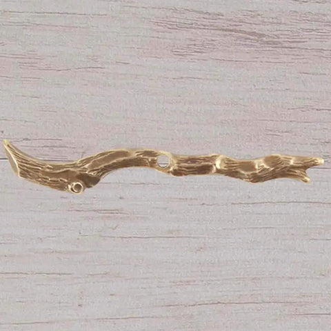 Metallic twig pendant on wooden surface, ideal for crafts and jewelry making.