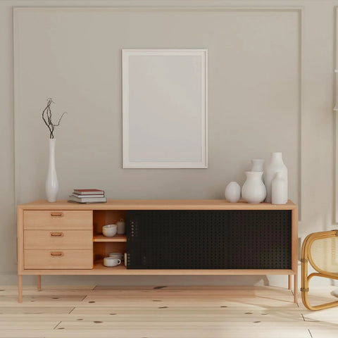 Modern living room with wooden cabinet, books, and vases on top, neutral decor style, wall art above, and chair on the side.