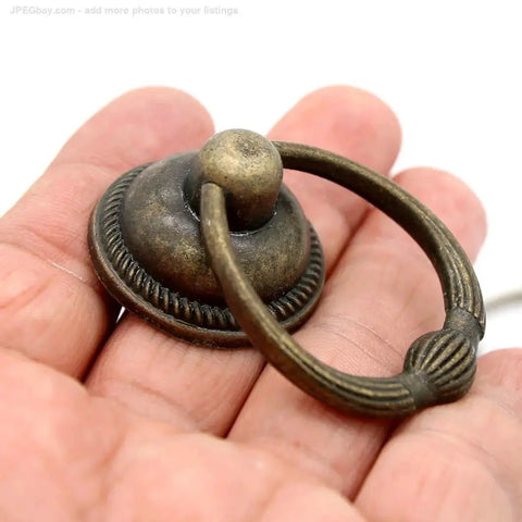Set Of 6 Vintage Antique Brass Drop Ring Pulls For Drawers With Single Mounting Hole Large Ring Size 1.4-Inch And Pull Height 2.1-Inch Retro Style Drawer Handles - close-up view showing detailed design and finish on hand