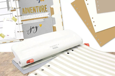 Adjustable Six Hole Punch for Pocket Journals and Planners, 8 Sheet Capacity, shown on a desk with punched paper and planners