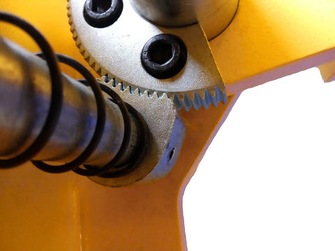 Two-post car lift gear assembly on a yellow post, close-up view showing exposed metal gears and seals