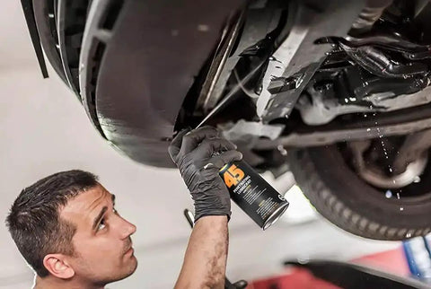 Mechanic applying Penetrating Lubricant For Metal Moving Parts, 17 Oz Can, Heavy Duty Oil That Slips In To Reduce Friction on car's underside