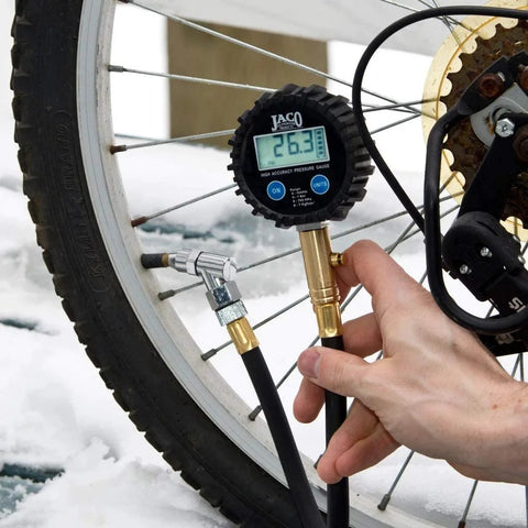 JACO ElitePro digital tire pressure gauge attached to bicycle tire valve, brass fittings, reading 26.3 psi.