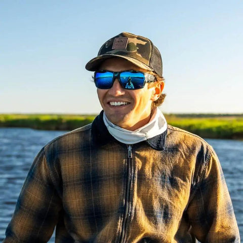 Angler wearing Vega Polarized Sunglasses with green mirror lenses and brown tortoise matte frame, ideal for shoreline fishing.