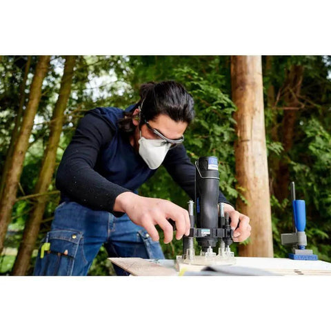 Person using Compact Plunge Router Attachment For Dremel Rotary Tool Lets You Cut Decorative Edges, Straight Slots And Circles And Inlay Work with visibility