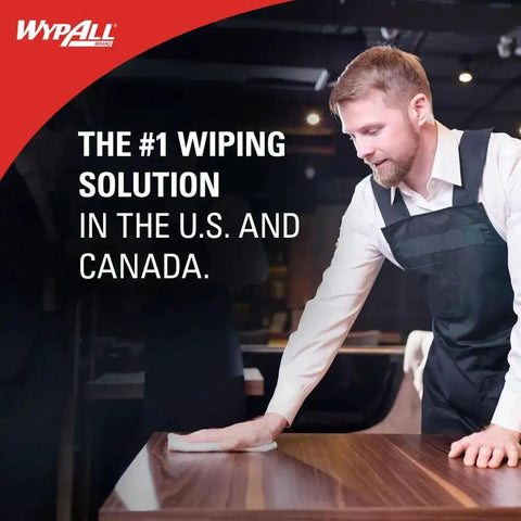 Man in uniform wiping a wooden table with WypAll product in a commercial setting.