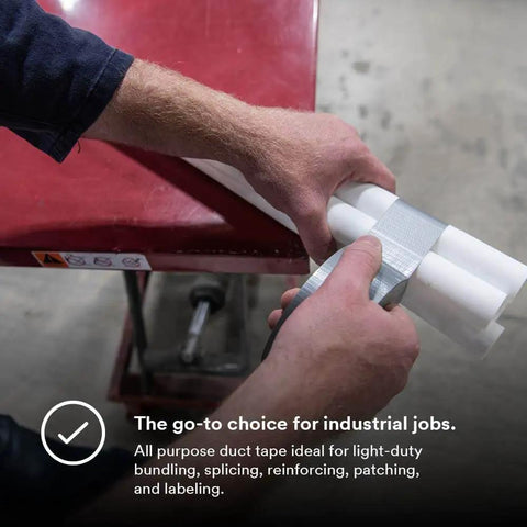 Person using Industrial Strength Silver Duct Tape 1.88 Inch By 60 Yard Pack Of 3 for bundling white pipes on red table