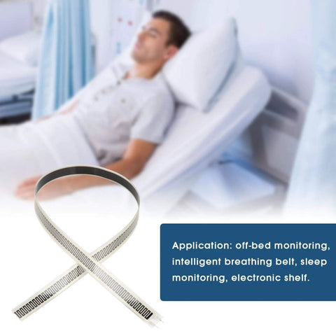 Thin-film force sensing resistor strip, white with interdigitated electrodes; used as sleep monitoring belt.
