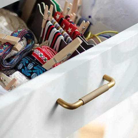 Open drawer with Six Pack 5 Inch Champagne Bronze Knurled Cabinet Pulls With Crosshatch Knurling, showing colorful storage