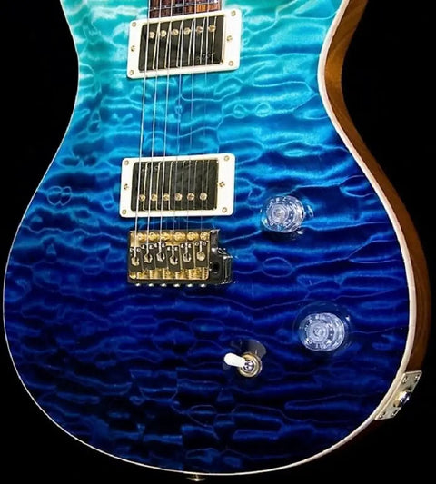 Blue electric guitar with dark blue to light blue gradient finish and silver hardware against a black background.