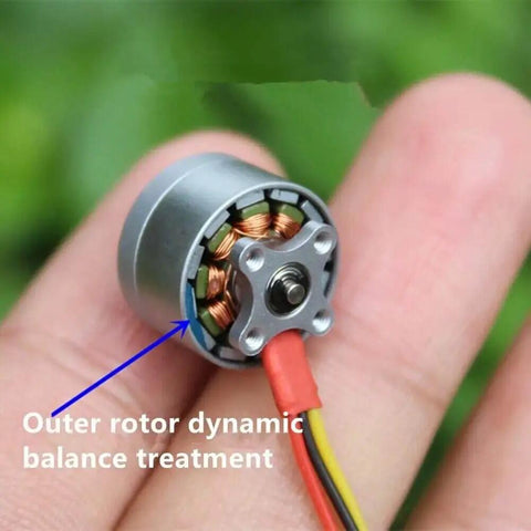 Close-up of a single brushless motor on a fingertip, showcasing the outer rotor dynamic balance treatment.