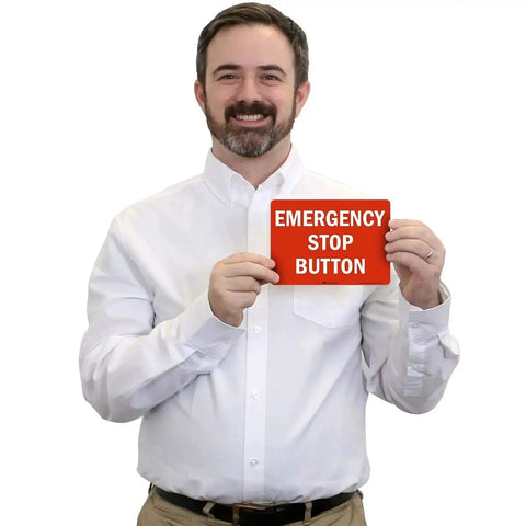 Man holding an Emergency Stop Button Label With Reflective Laminated Vinyl, 7 By 5 Inches, showing durable outdoor signage.