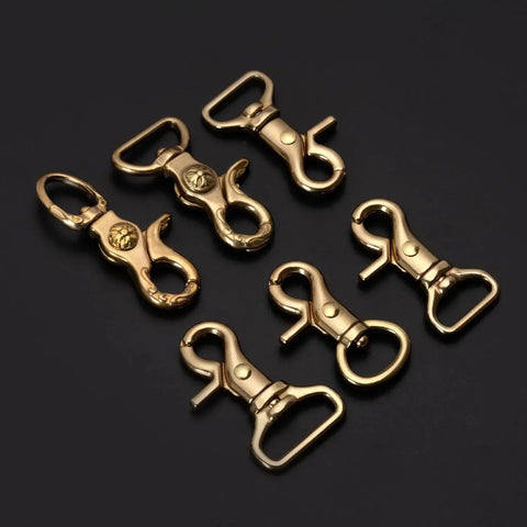 Solid Brass Trigger Snap Hooks Lobster Clasps Swivel Straps Bags Leathercraft in various sizes on black background.