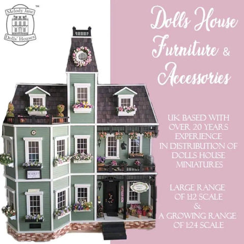 Front view of a green dollhouse with floral decorations, showcasing multiple windows and detailed architectural features.