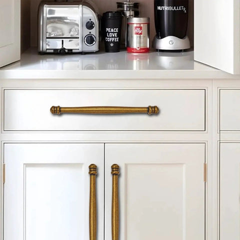 10 Pack Center To Center Three And A Half Inch Antique Brass Cabinet Pulls installed on white kitchen cabinets and drawer.