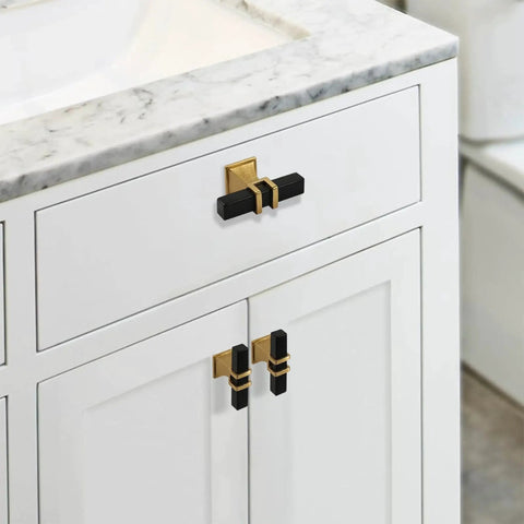 Two Pack Square Black And Gold T Bar Cabinet Handles on white cabinet with marble countertop, stainless steel single hole center mount