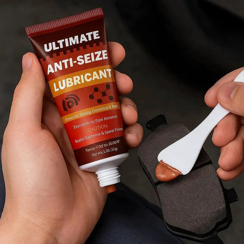 Person applying lubricant from a tube labeled 'Ultimate Anti-Seize Lubricant' onto a metal surface using a white spatula.
