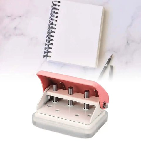 Ultimate Handheld 3-Hole Paper Puncher with 5-Sheet Capacity shown with notebook and pen on marble surface